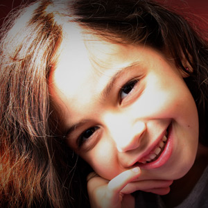 Retrato de uma menina iluminada com flash externo e sombrinha